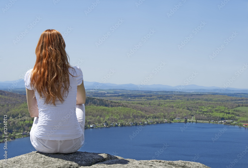 Young woman on top of a mountain