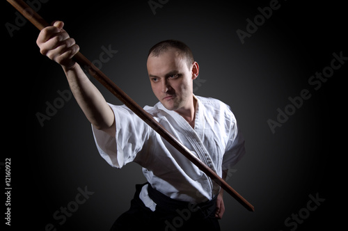 Man in white with wooden sword photo