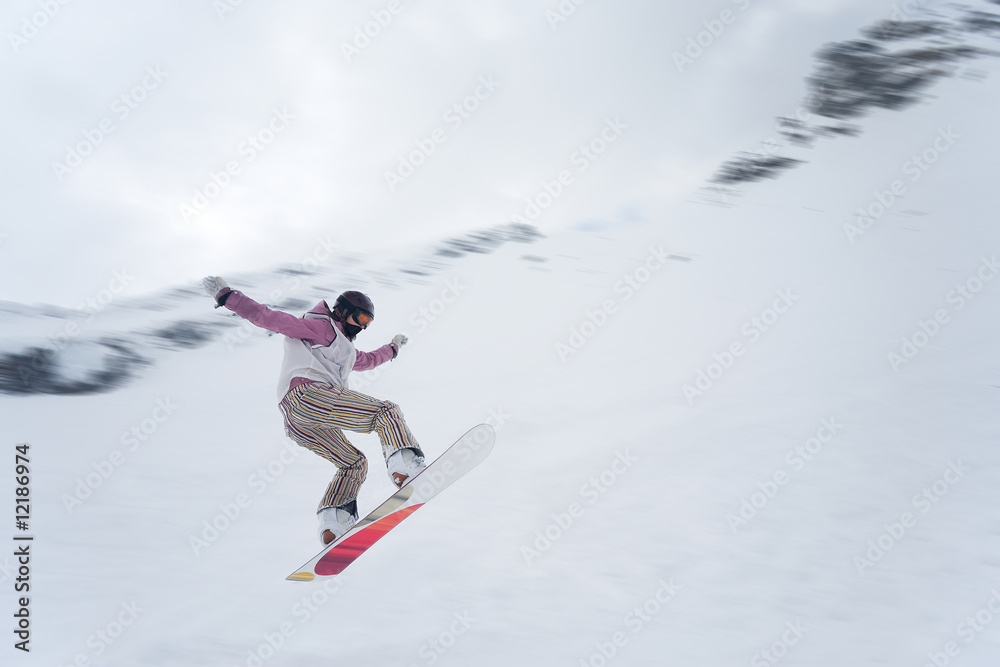 Girl with snowboard jumping of a hill