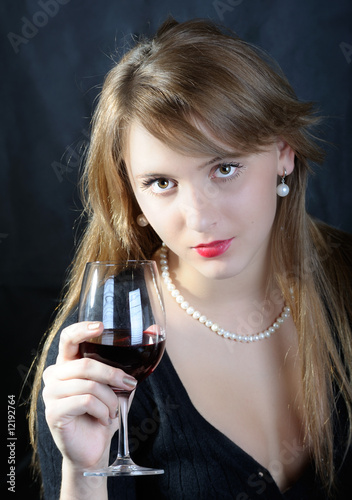 Beautiful young woman with glass of red wine