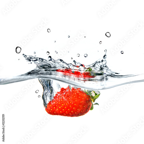 strawberry dropped into blue water with splash isolated on white