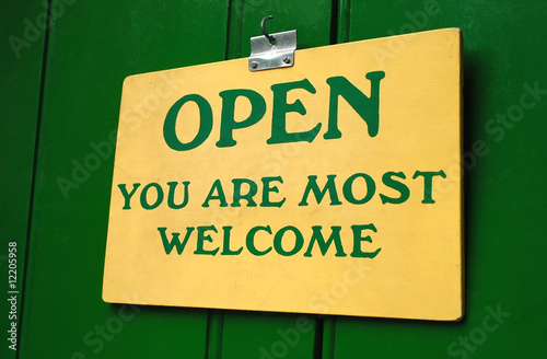 polite old welcome sign hanging in a doorway