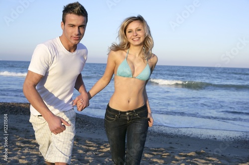 couple running at beach  young and beautiful