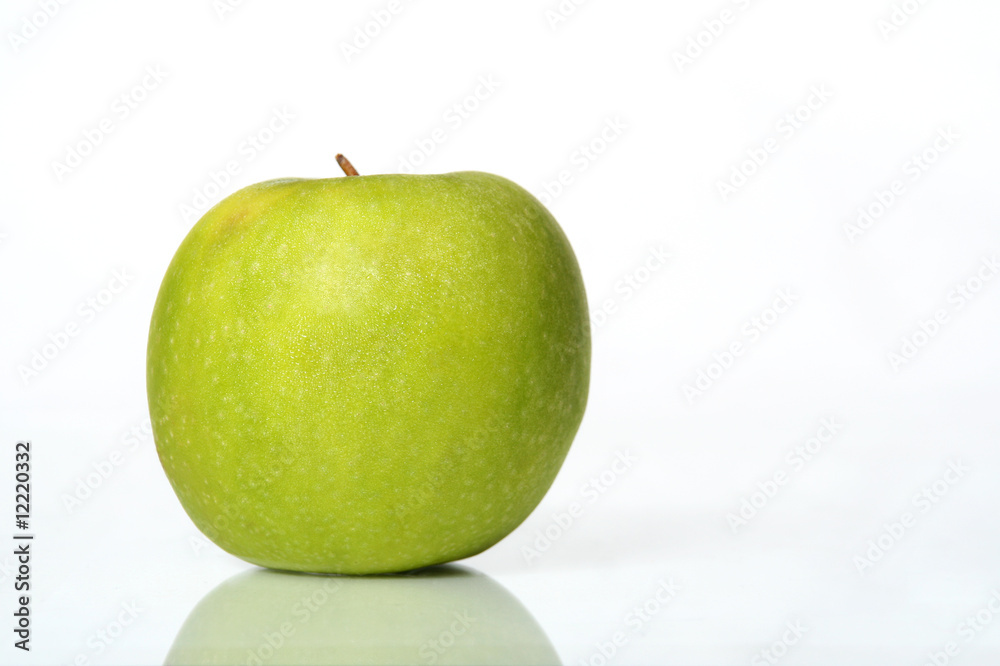 Juicy wet green apple on a table with isolated white background Juicy wet green apple on a table with isolated white background