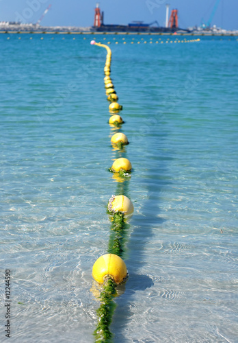 Yellow floats line near unfinished Palm Deira. UAE.