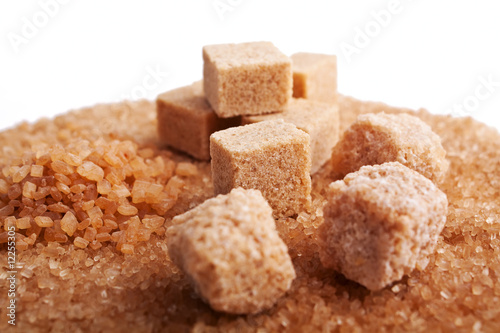 brown sugar cubes isolated on sugar crystals background