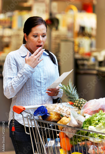 Frau kontrolliert Kassenzettel im Supermarkt photo