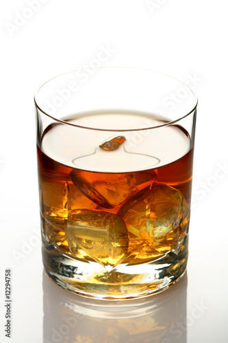 Glass of whiskey on rocks isolated on white