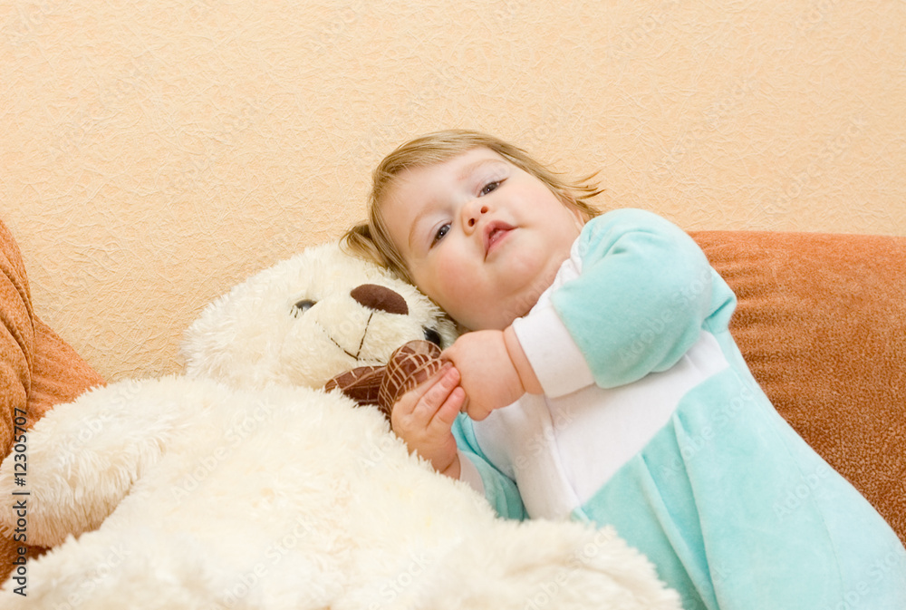Small baby sitting in armchair with toy bear Small baby sitting in armchair with toy bear