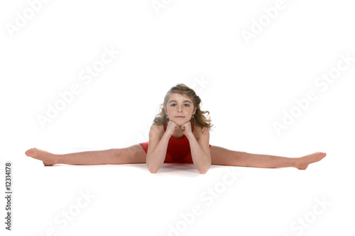 young girl doing a split with her hands under her chin