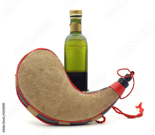 Cuadro en lienzo Old bottle behind a tan colored wine skin.