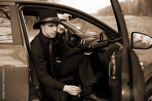 man in car with cigar and rifle