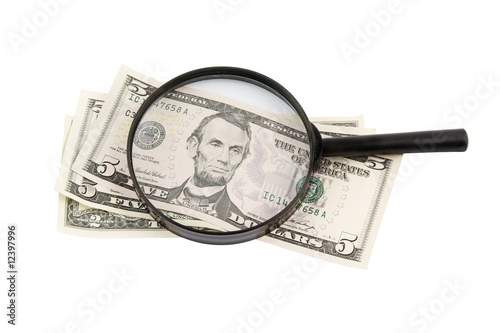 Black magnifying lens and dollars isolated on white