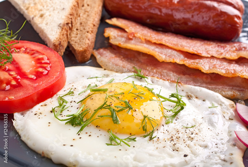 classic breakfast with fried egg  sausages  bacon and toast