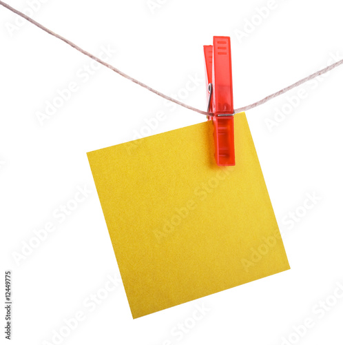 Yellow  reminder note hanging on a red clothespin