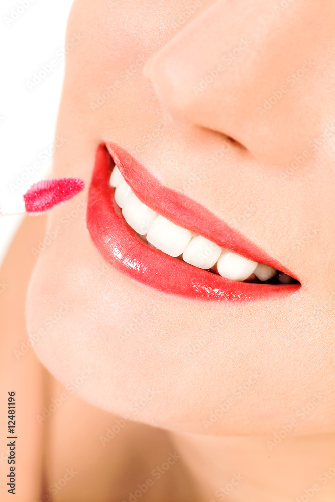 Naklejka premium Putting on lip gloss