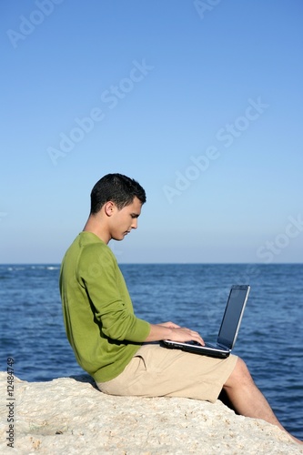 Handsome young businessman computer beach