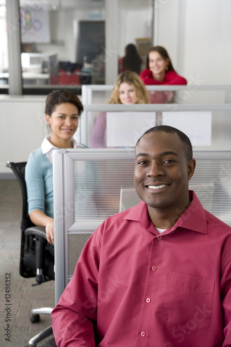 Businessman and co-workers sitting in cubicles