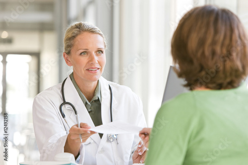 Attractive young caring doctor talking to patient