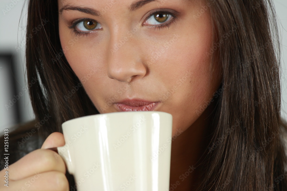Young woman with beautiful face is having her tea/coffee Young woman with beautiful face is having her tea/coffee