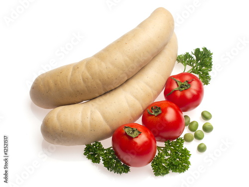 White sausage decorated with tomato, parsley and green pea photo