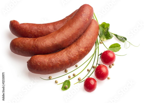 Smoked sausages decorated with tomatoes, onion, pepper photo
