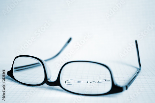 Glasses and paper with Albert Einstein's E=mc2