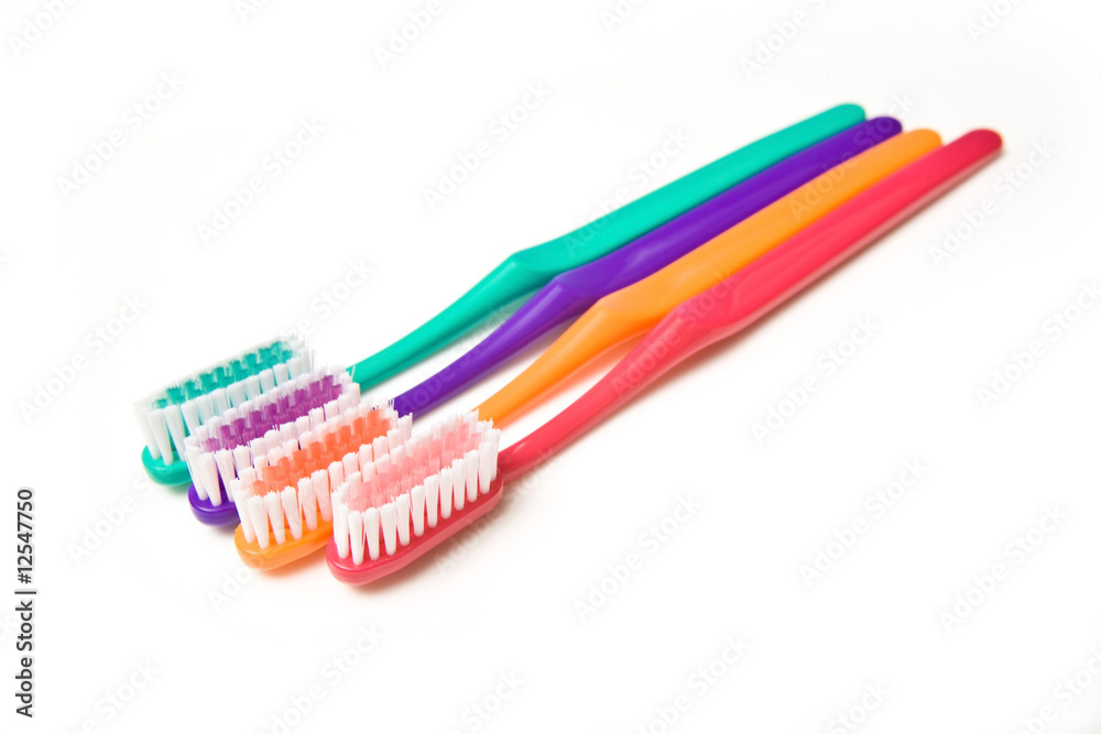 Coloured toothbrushes isolated on a white studio background. Coloured toothbrushes isolated on a white studio background.