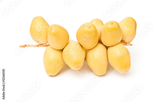 Fresh yellow dates isolated on a white studio background.