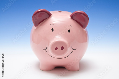 Piggy bank style money box on a blue studio background.