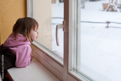 Girl and winter behind window.