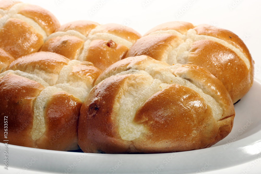 Easter hot cross buns stacked on a flat plate