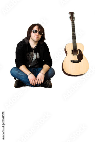 a young musician sits with the guitar