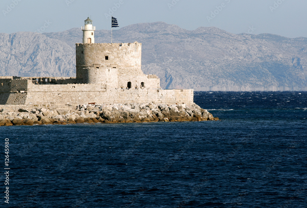 Lighthouse of Rhodes, Greece, built in fortress with Greek flag