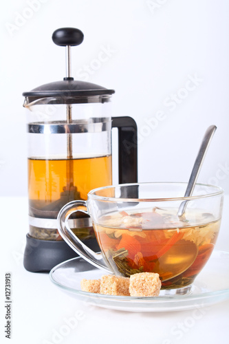 a cup of green tea with chrysanthemum and a french press