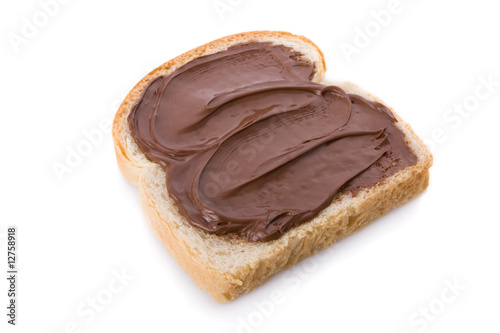 Hazelnut and chocolate spread over a slice of bread.