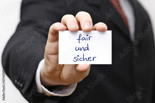 Mann hält Karte mit fair und sicher