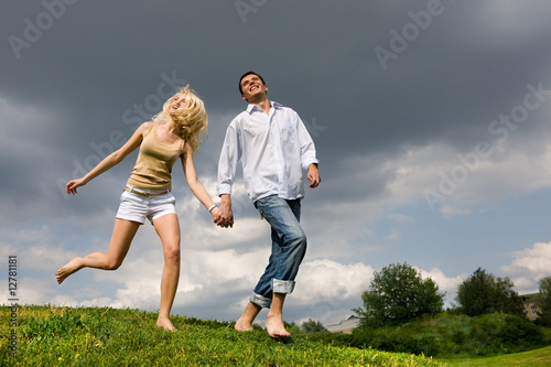 Young couple walking through summer lawn