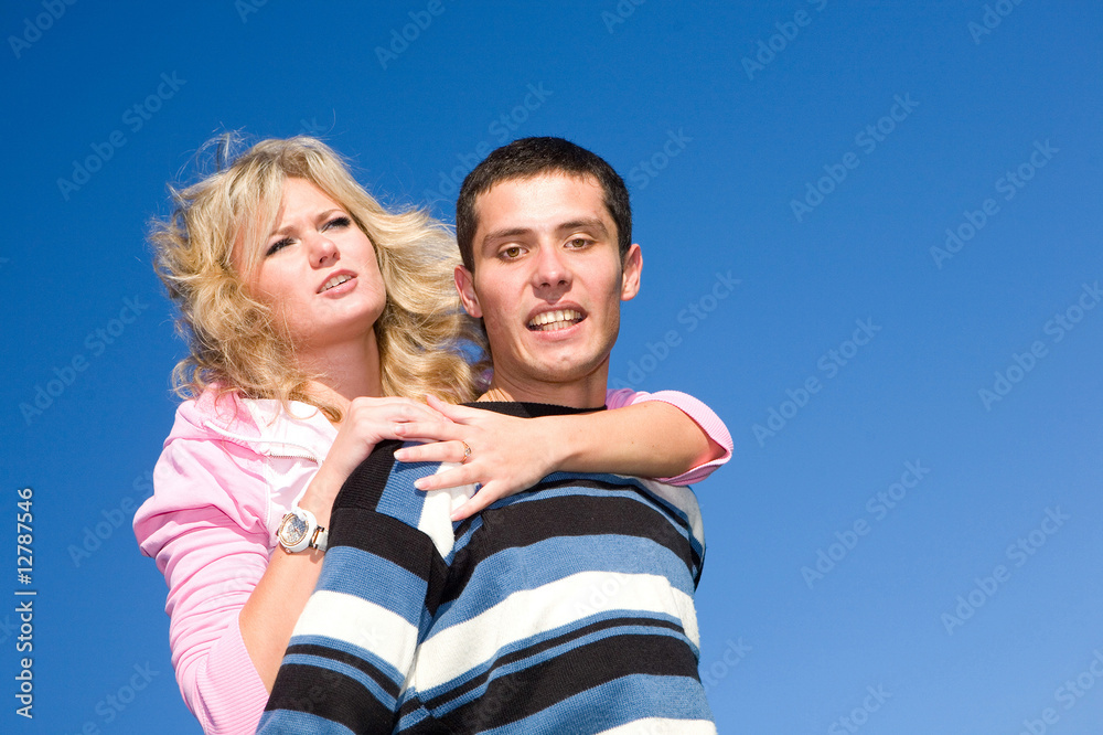 Fototapeta premium Young love couple smiling under blue sky