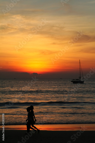 Bambini che camminano in spiaggia durante il tramonto