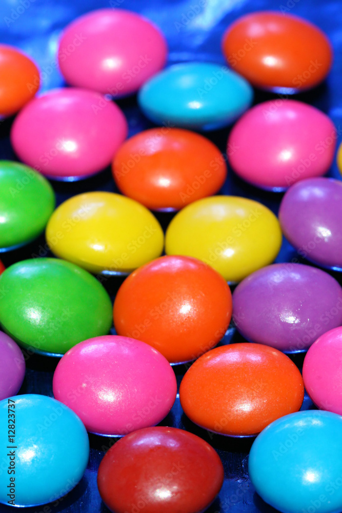 A pile of chocolate candies with a colorful outer shell A pile of chocolate candies with a colorful outer shell