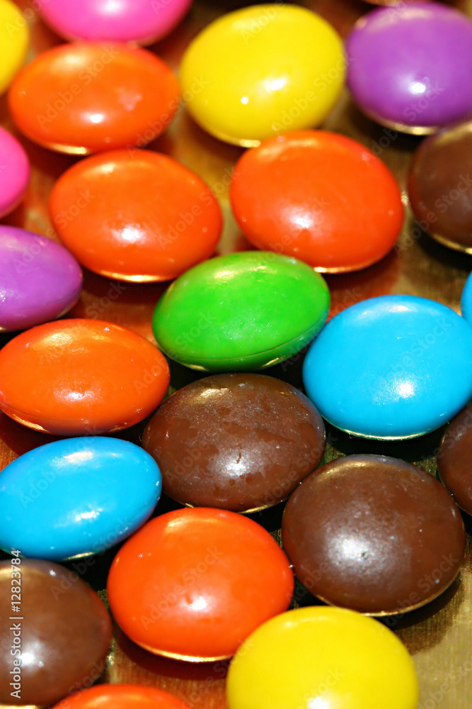 A pile of chocolate candies with a colorful outer shell A pile of chocolate candies with a colorful outer shell