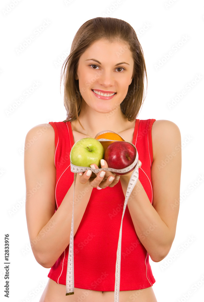 Beautiful girl holding fruits and a measure tape; isolated on wh Beautiful girl holding fruits and a measure tape; isolated on wh
