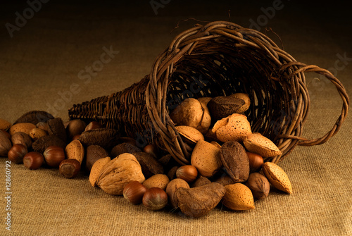 Assortment of nuts in basket on hesian background photo