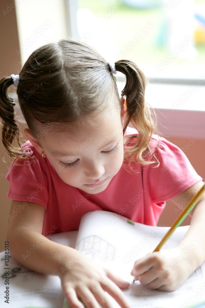 Little toddler girl writing at school desk Little toddler girl writing at school desk