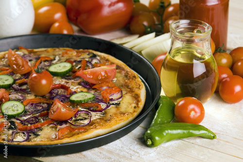 Pizza dish on wooden floor with chilli