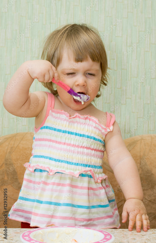Small funny eating girl in dress