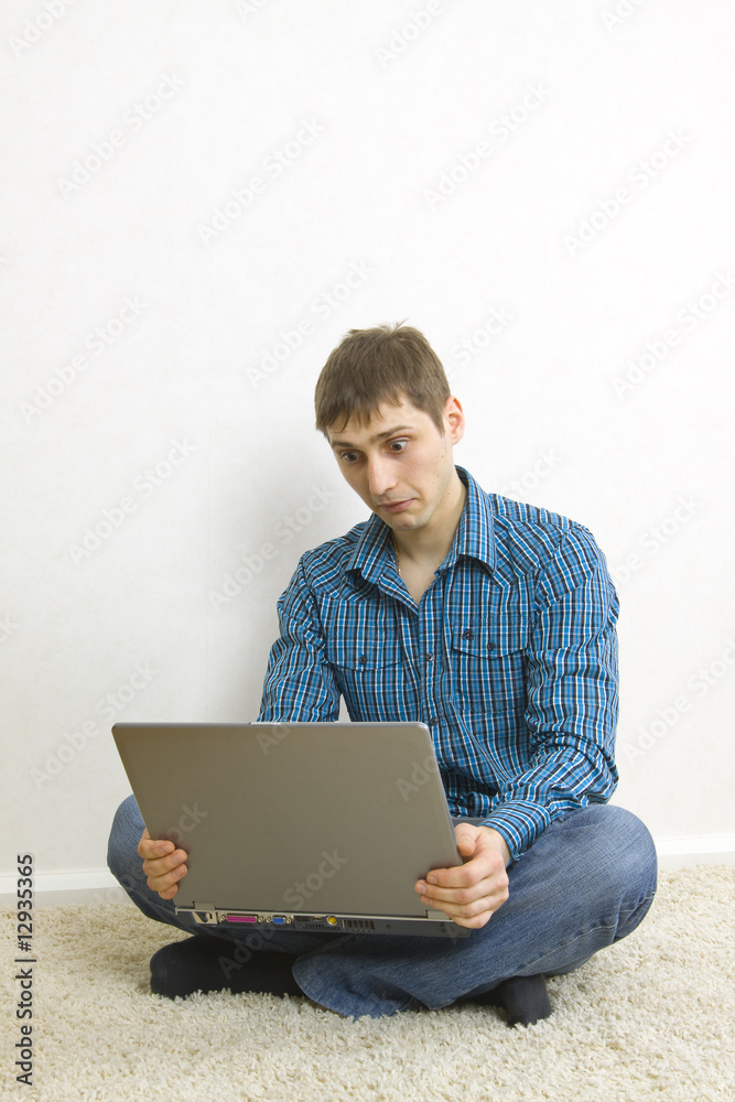 man sitting on the floor using a laptop man sitting on the floor using a laptop