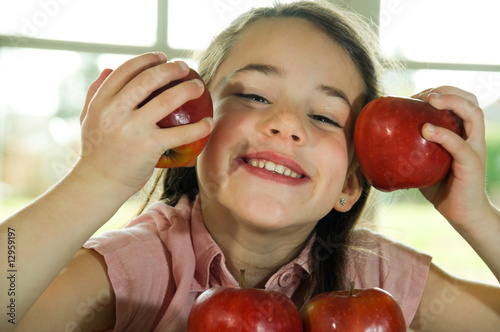brown haired child playing with apples