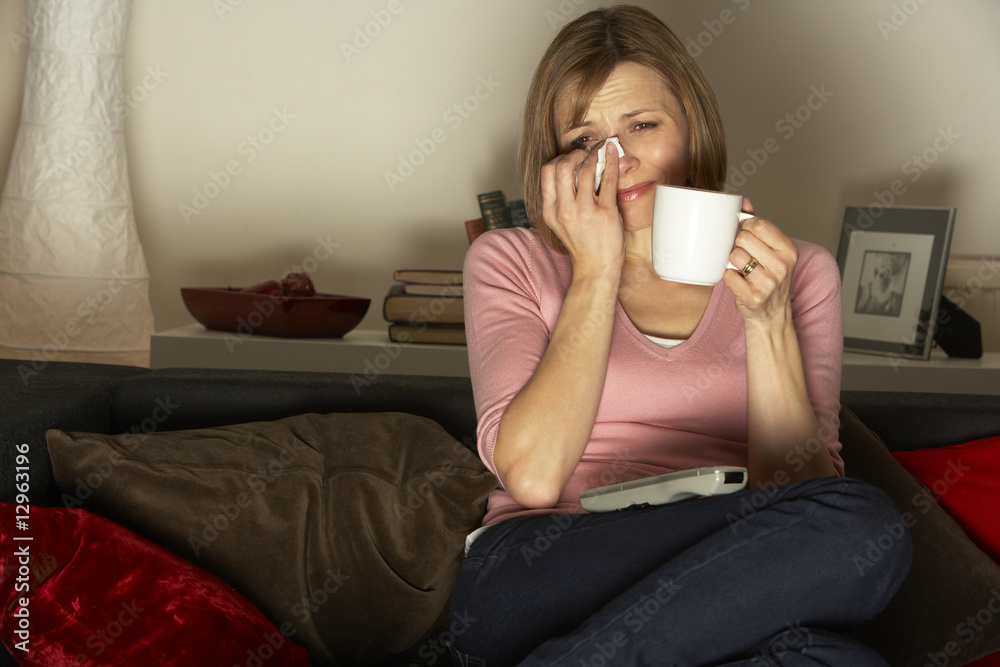 Woman Relaxing With Cup Of Coffee Watching Television